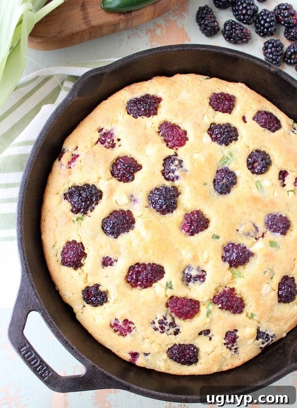 Hand holding a slice of Blackberry Serrano Cornbread