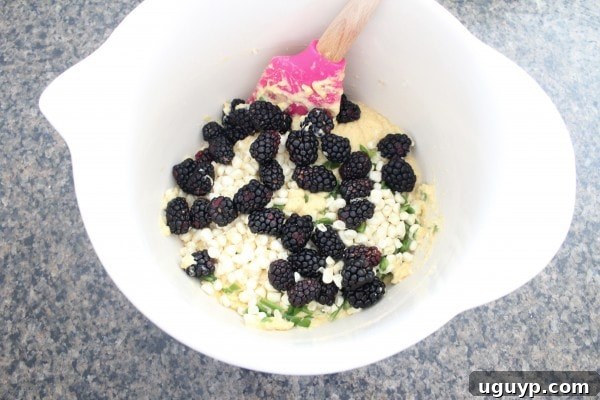 Blackberry Serrano Cornbread batter in a bowl with fruit and peppers