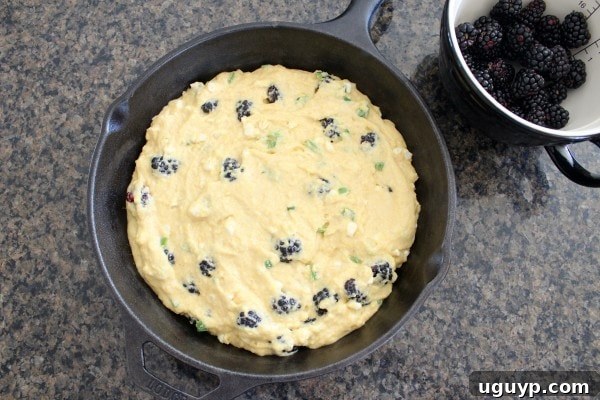 Blackberry Serrano Cornbread batter poured into a cast iron skillet