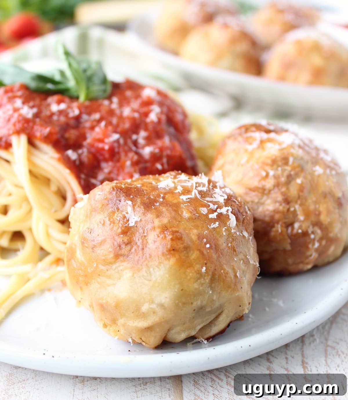 Puff Pastry Wrapped Meatballs on plate with spaghetti and marinara sauce