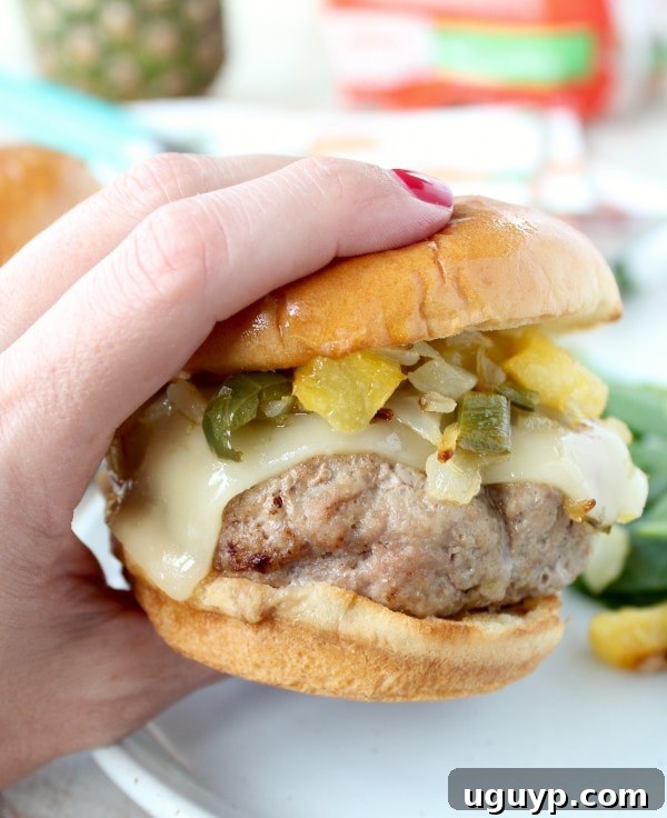 Two Hawaiian Turkey Burgers on toasted King's Hawaiian buns with relish and melted cheese, garnished with a sprinkle of green onion.