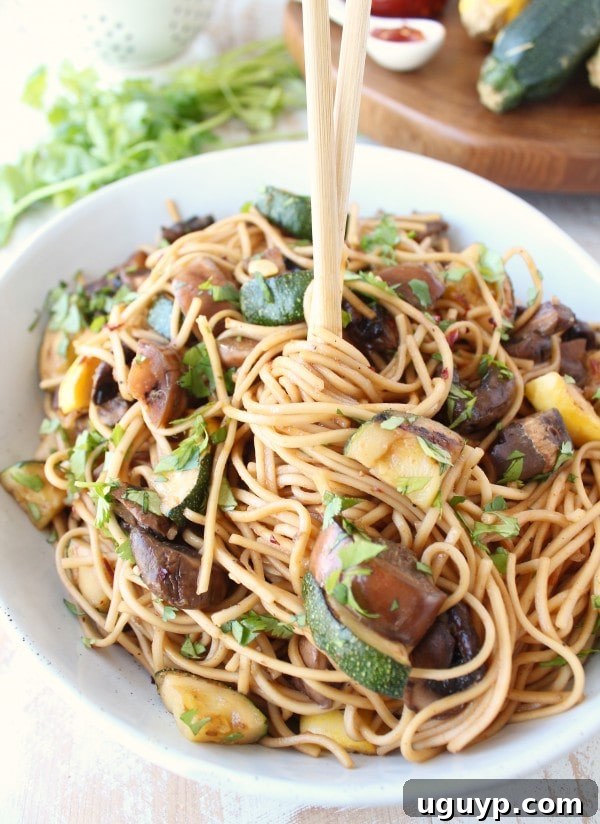 A beautifully presented bowl of Grilled Vegetable Lo Mein, garnished with fresh herbs
