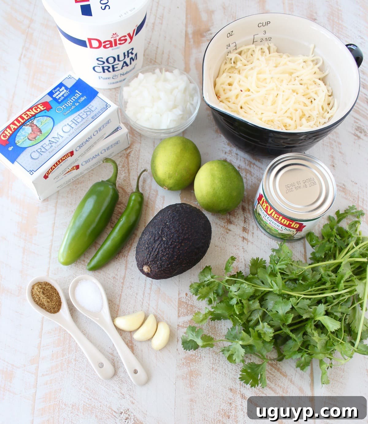 Fresh ingredients for slow cooker queso blanco laid out on a white wooden board