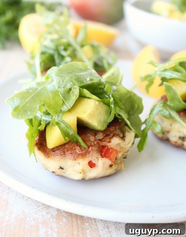 Plating coconut crab cakes with mango arugula salad