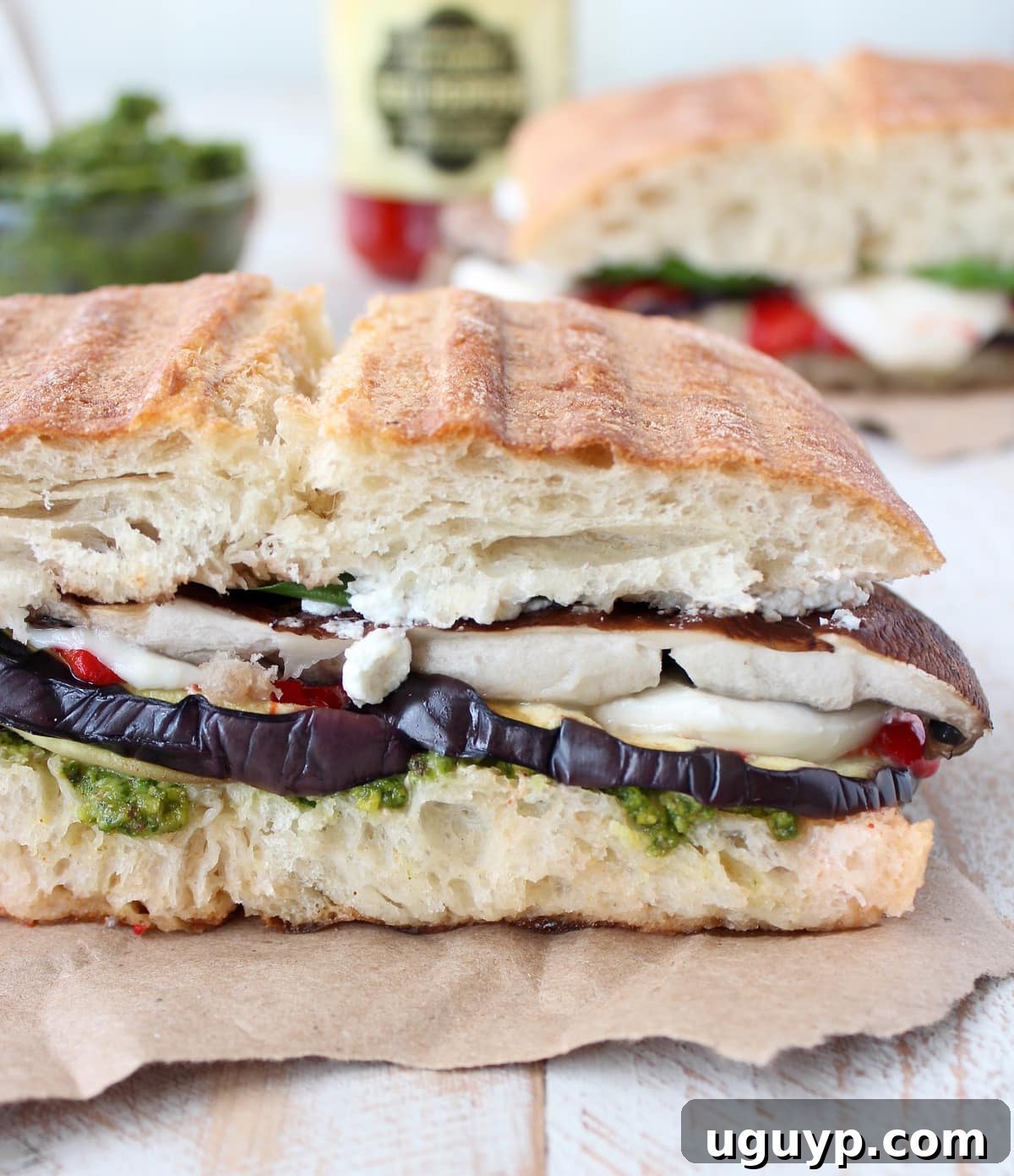 Vegetarian Italian Panini on a piece of paper on a white wood board