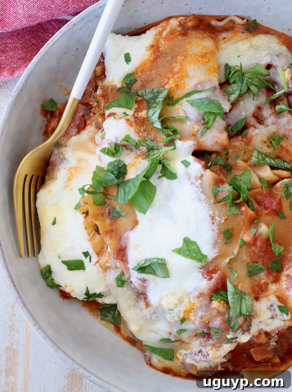 A bowl of freshly cooked one-pot lasagna, garnished with basil, with a fork ready to dig in, highlighting the rich cheese and sauce.