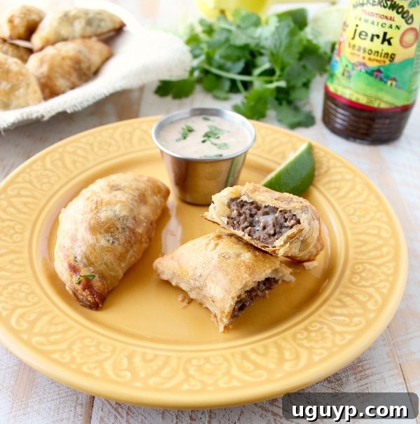 A beautifully presented plate of Jamaican Jerk Beef Patties, garnished with fresh herbs.