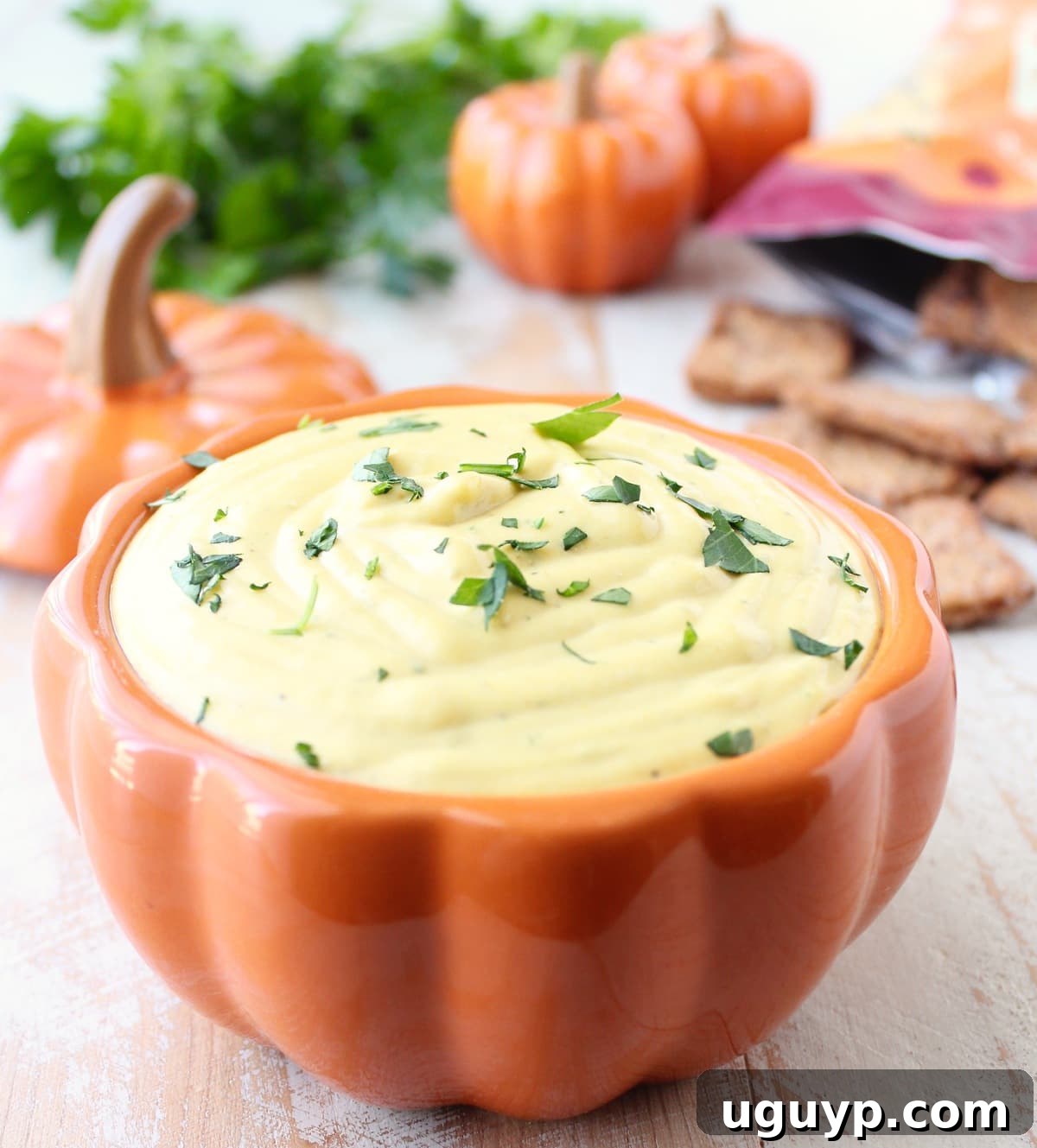 Creamy Jalapeno Pumpkin Dip served in an elegant pumpkin-shaped bowl, garnished with fresh parsley.