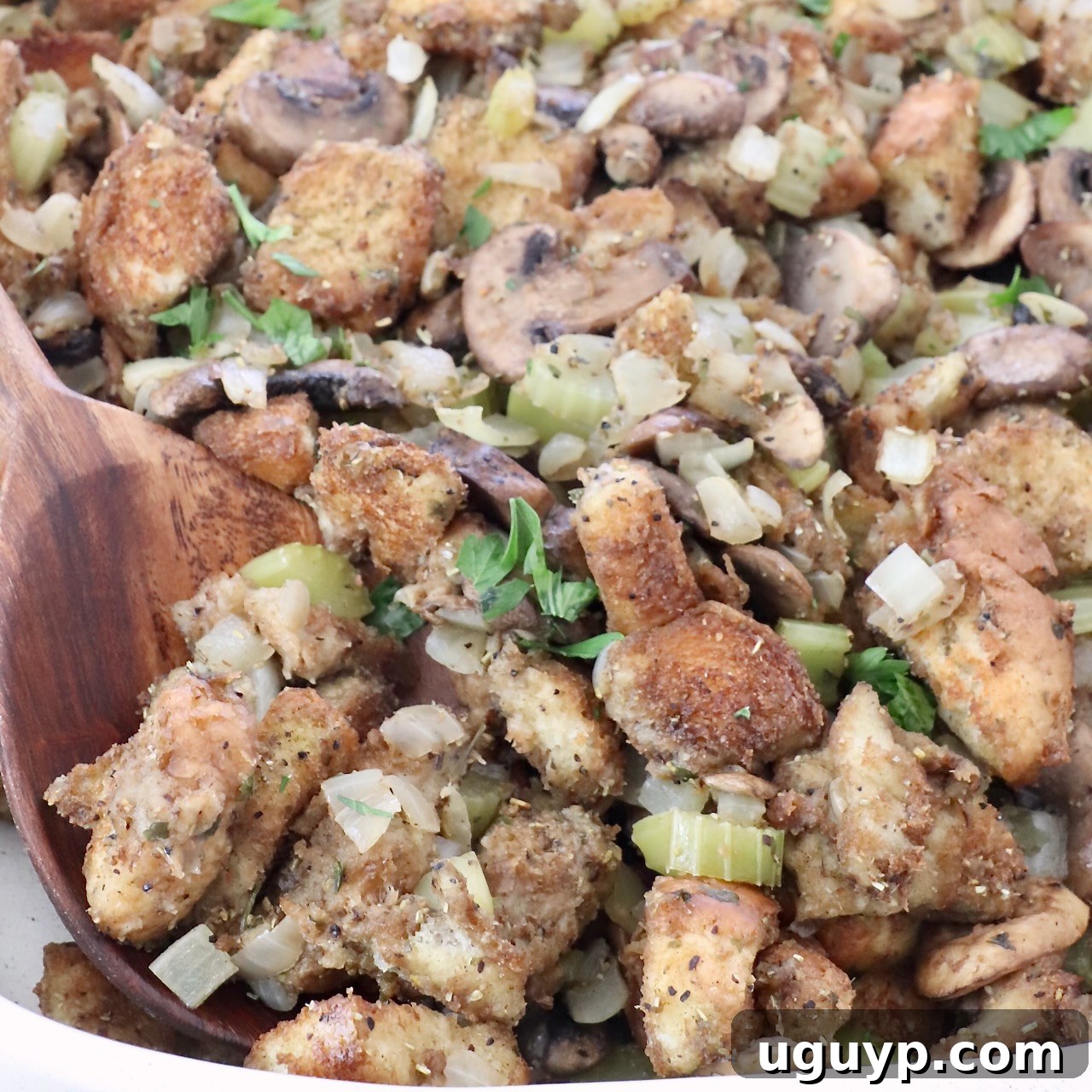 mushroom stuffing in a baking dish with a serving spoon