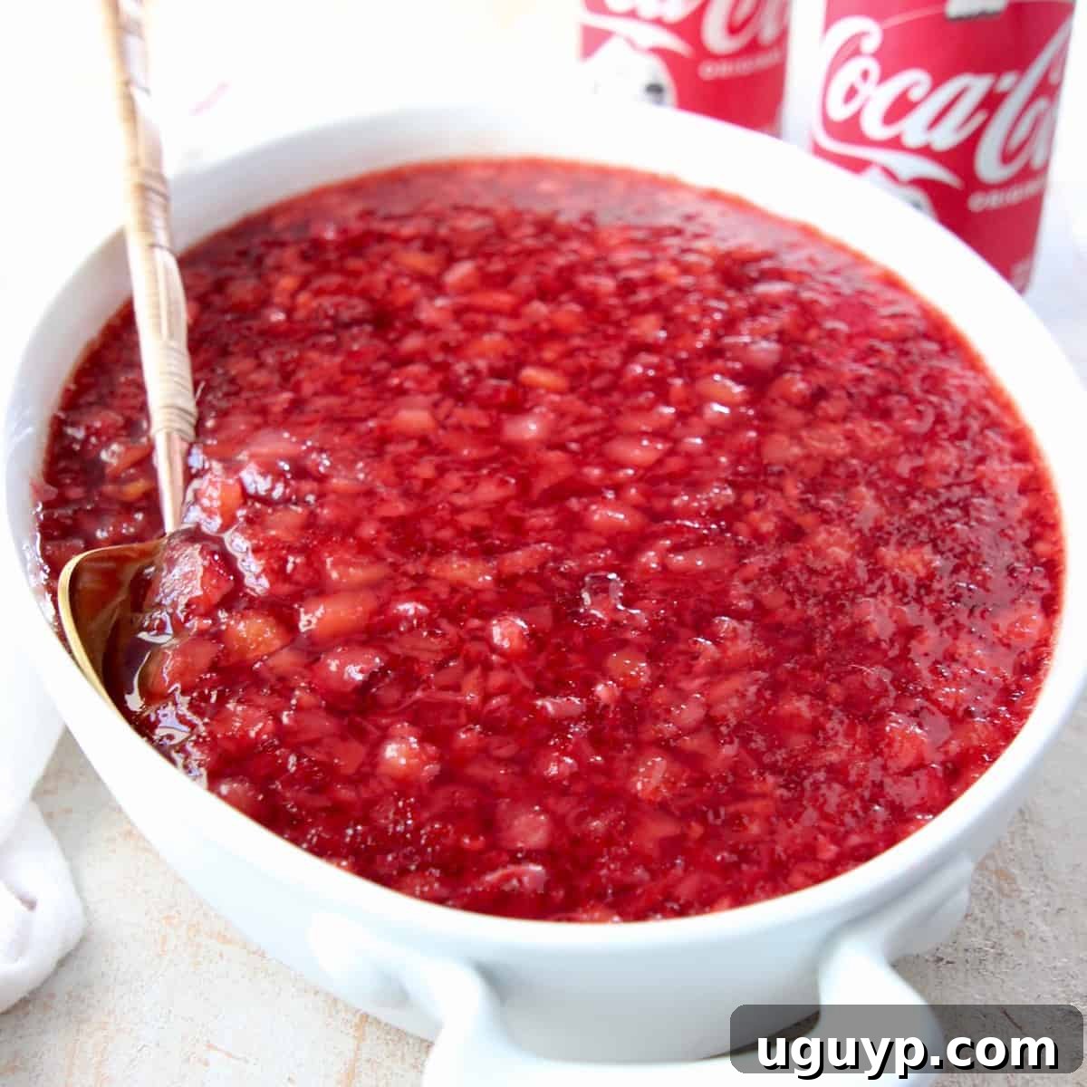 cherry jello salad in white serving bowl with spoon
