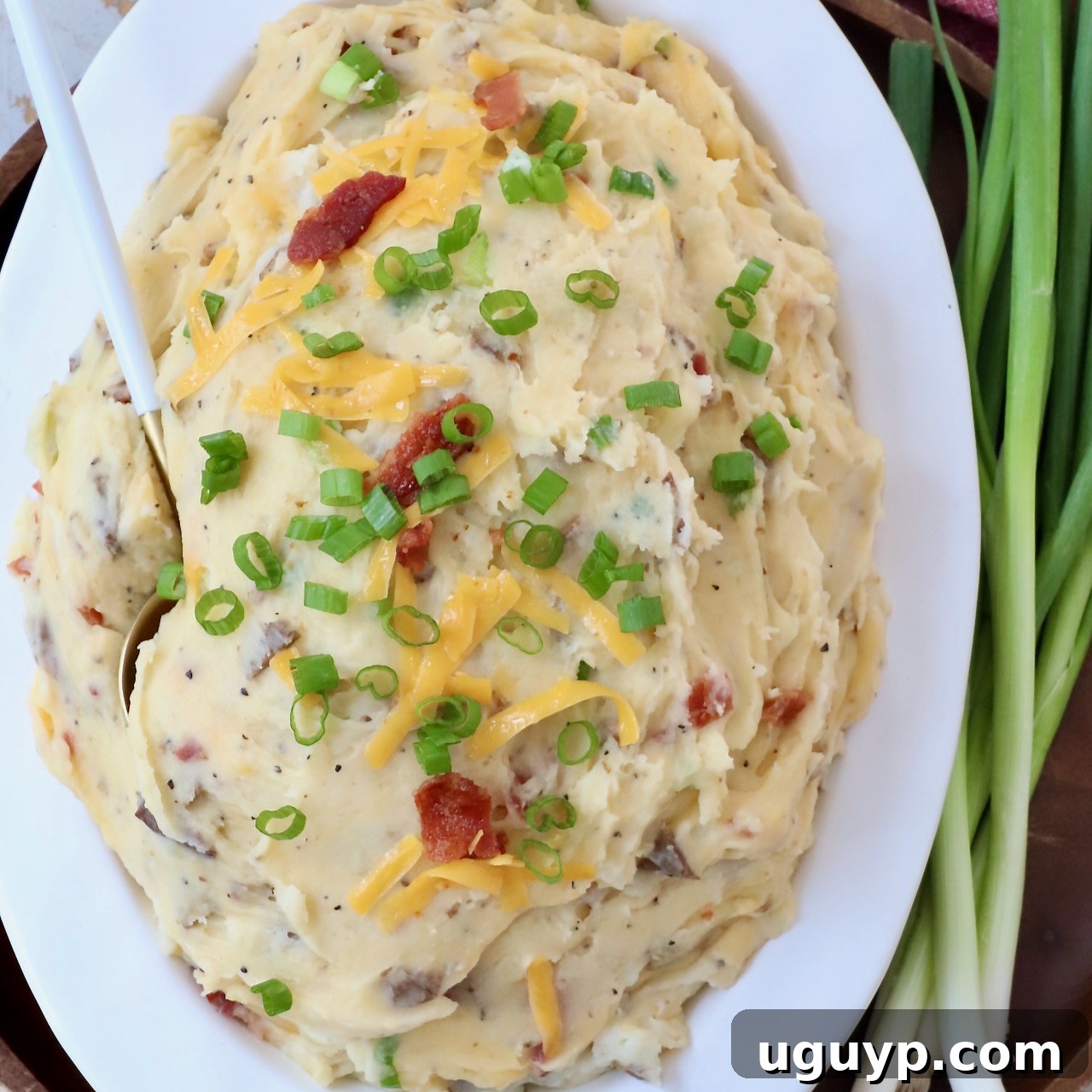 loaded mashed potatoes in serving dish with spoon