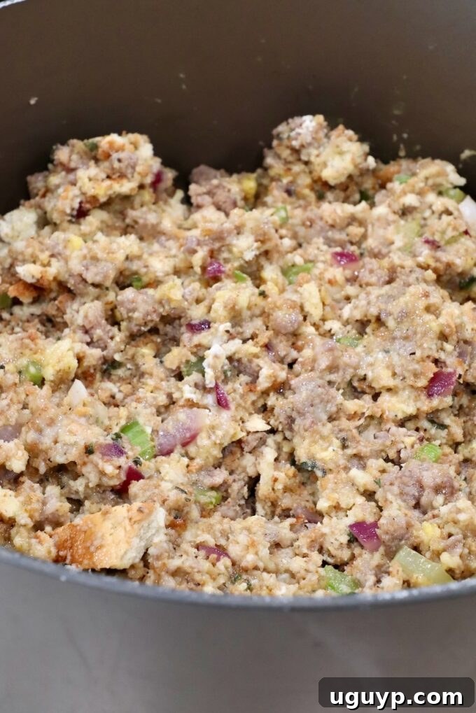 Uncooked sausage stuffing mixture in a large pot before baking