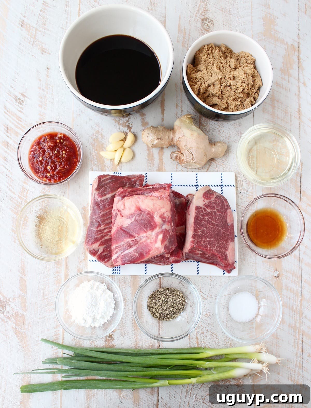 Ingredients for homemade Korean BBQ short ribs laid out on a white wooden board, showcasing fresh, high-quality components.