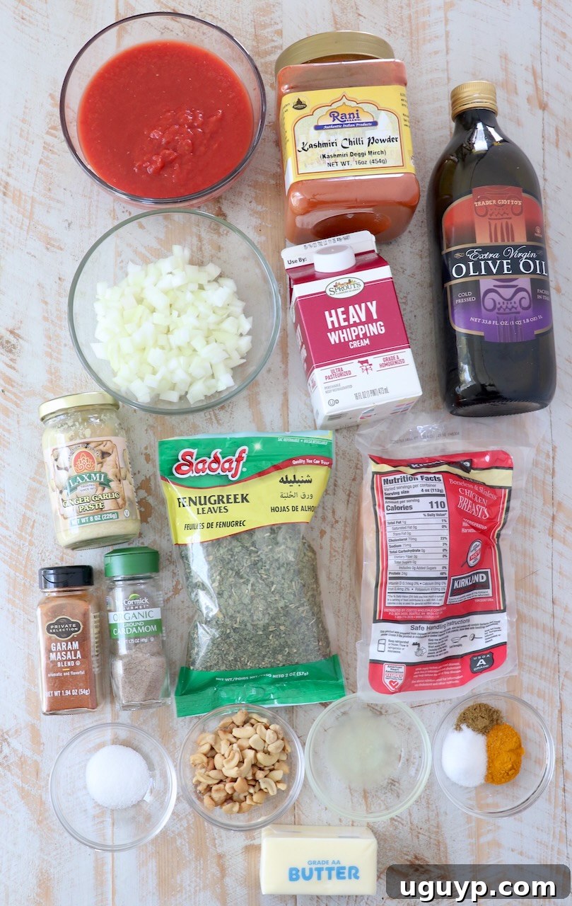 ingredients for Indian butter chicken on white wood board