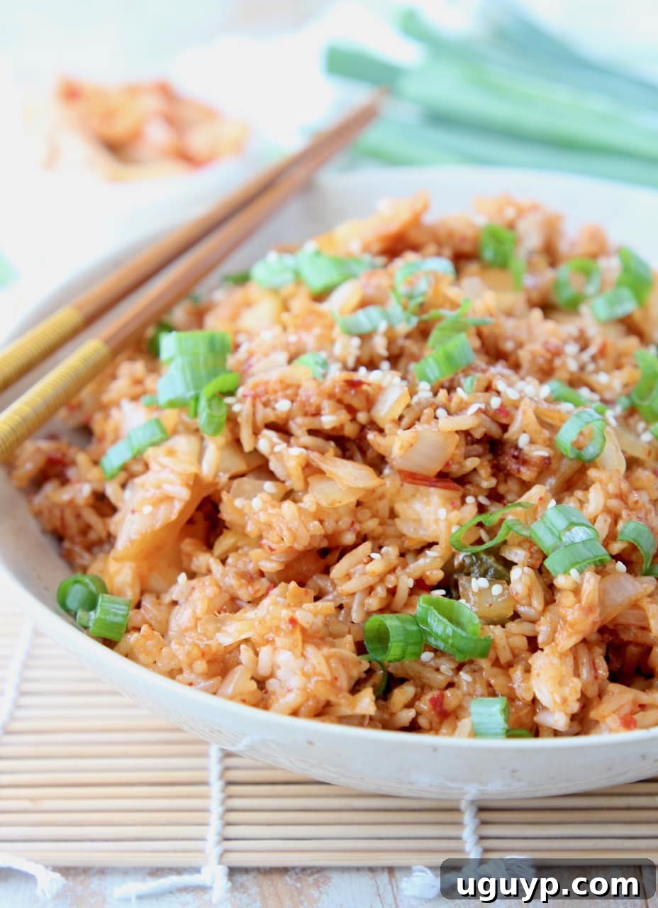 Fried rice in bowl with chopsticks, topped with diced green onions