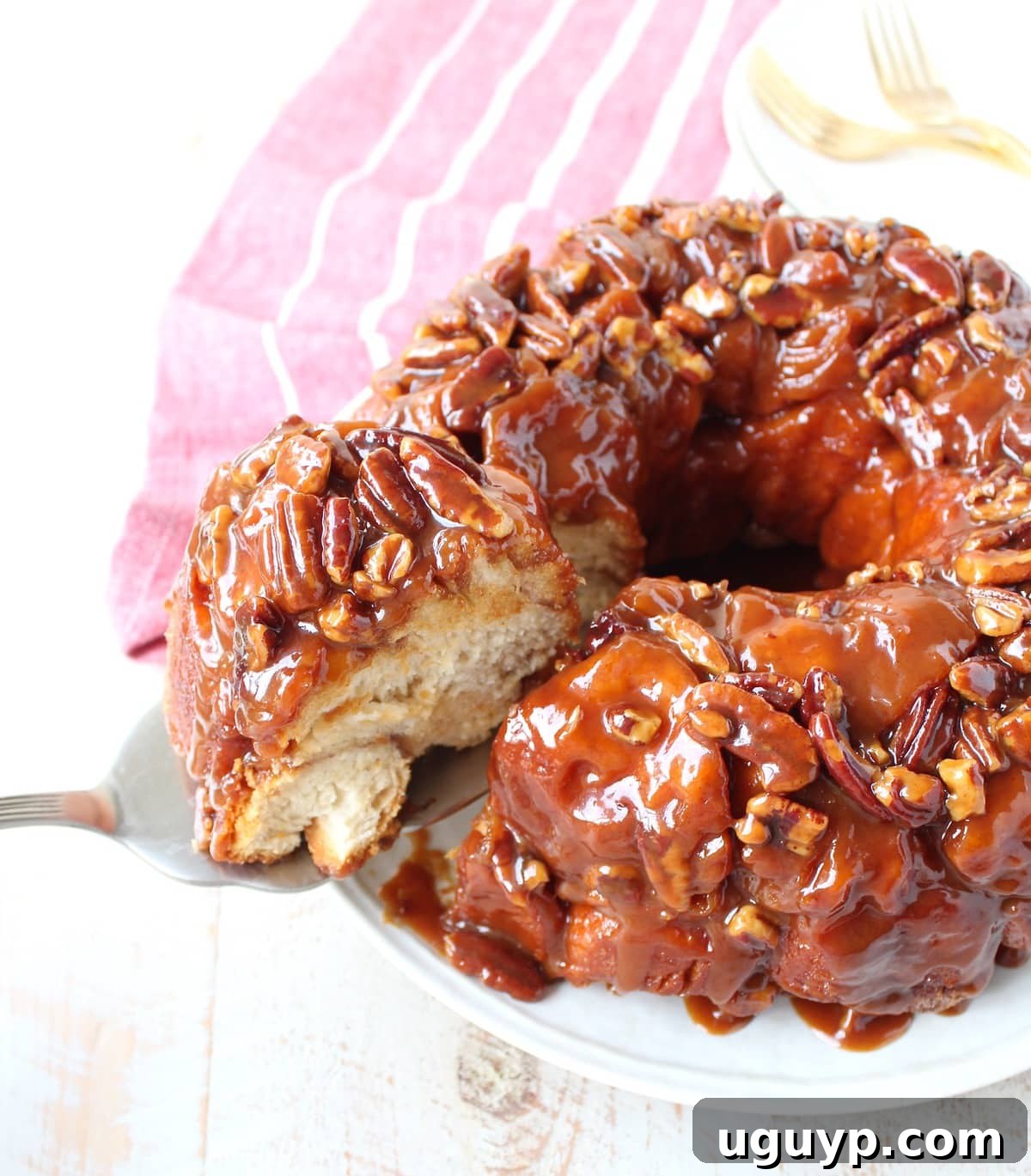 A slice of Salted Caramel Pecan Monkey Bread on a white plate, ready to be served.
