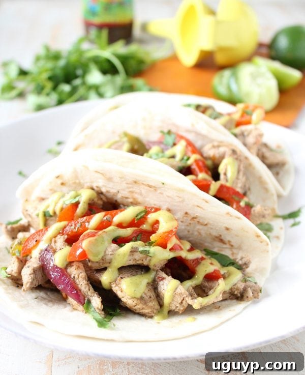 Close-up shot of sizzling Jerk Chicken and colorful bell peppers in a skillet, showcasing the rich marinade and fresh ingredients for a quick and tasty fajita dinner.