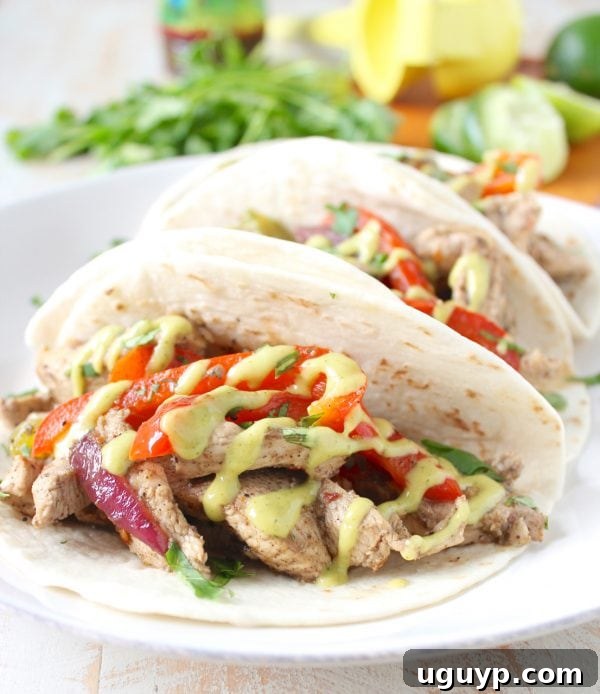 An inviting overhead view of a dinner setting with Jerk Chicken Fajitas, warm tortillas, and various fresh toppings like lime wedges, cilantro, and sauces, encouraging customization.