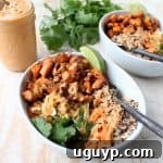 Roasted sweet potatoes and quinoa are topped with delicious Thai peanut sauce in this healthy, gluten free & vegan buddha bowl recipe!