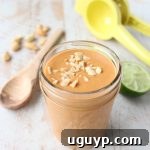 A mason jar of homemade Thai Peanut Sauce, perfect for drizzling over buddha bowls or tossing with noodles.
