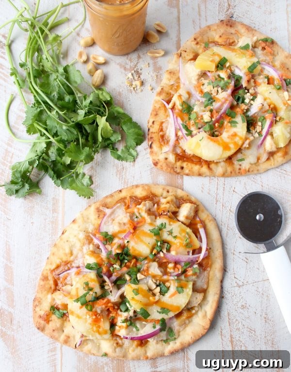Delicious Thai Peanut Chicken Naan Pizza with red onion, pineapple, and fresh cilantro garnish, ready in under 30 minutes.