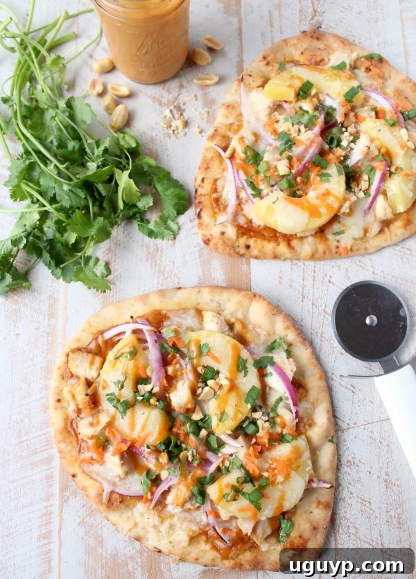 Final presentation of a delicious Thai Peanut Chicken Naan Pizza, inviting viewers to enjoy.