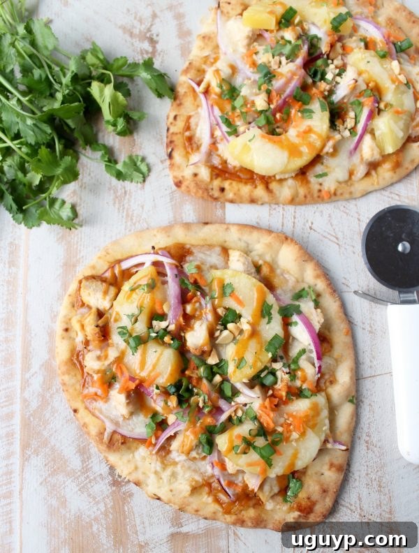 Freshly baked Thai Peanut Chicken Naan Pizza removed from the oven, garnished and ready to slice.