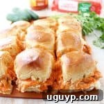 A plate of two freshly baked Jalapeño Buffalo Chicken Dip Sliders.