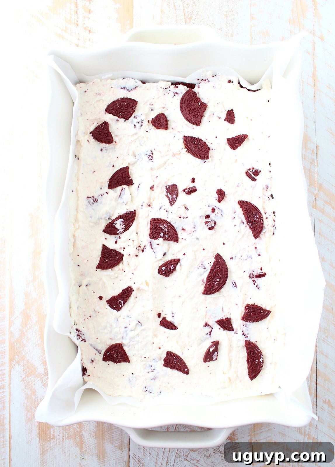 The Red Velvet Oreo cheesecake bars, freshly assembled with cookie pieces on top, ready for freezing.