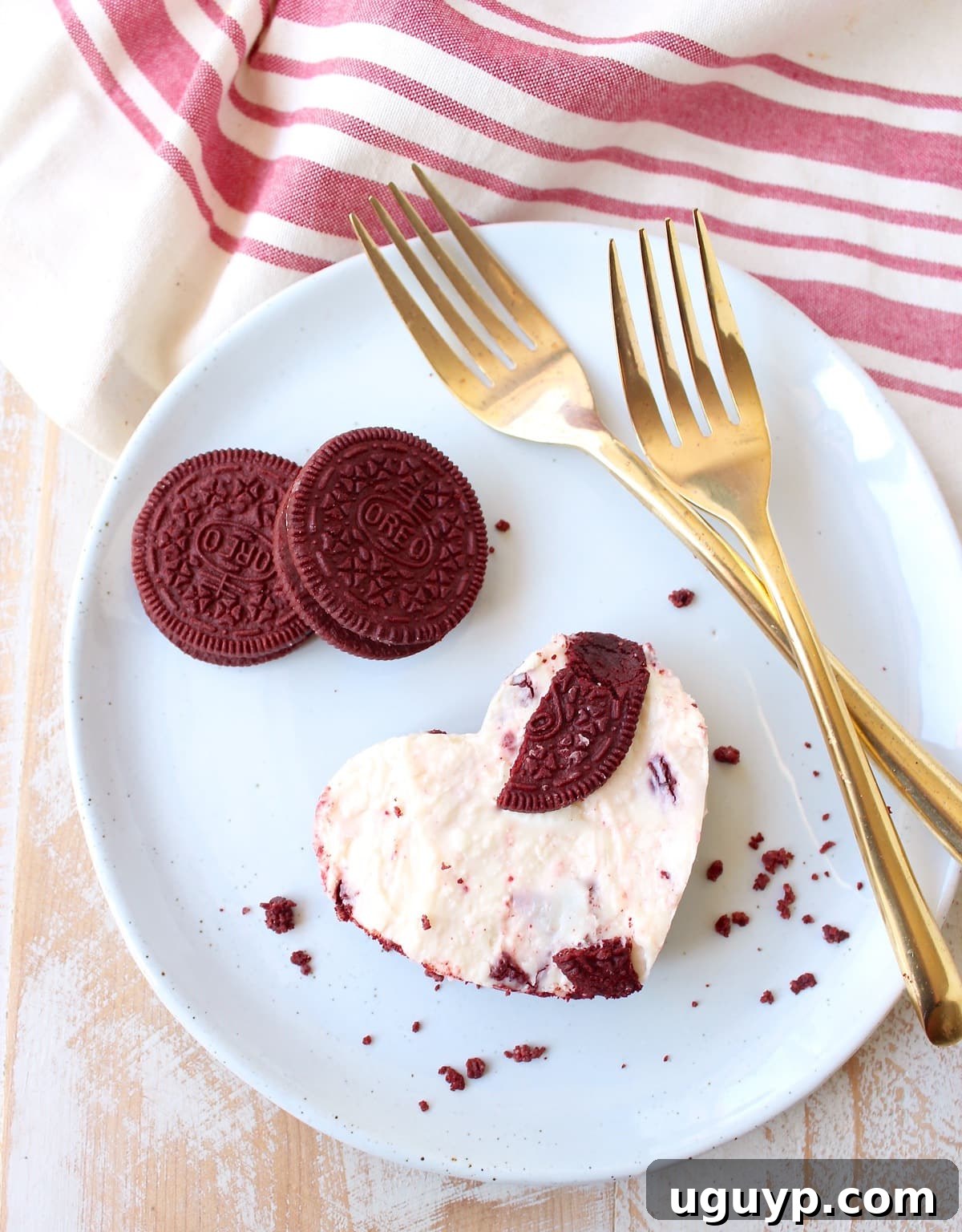 Close-up of a heart-shaped Red Velvet Oreo cheesecake bar, highlighting its creamy texture and crumbly crust.