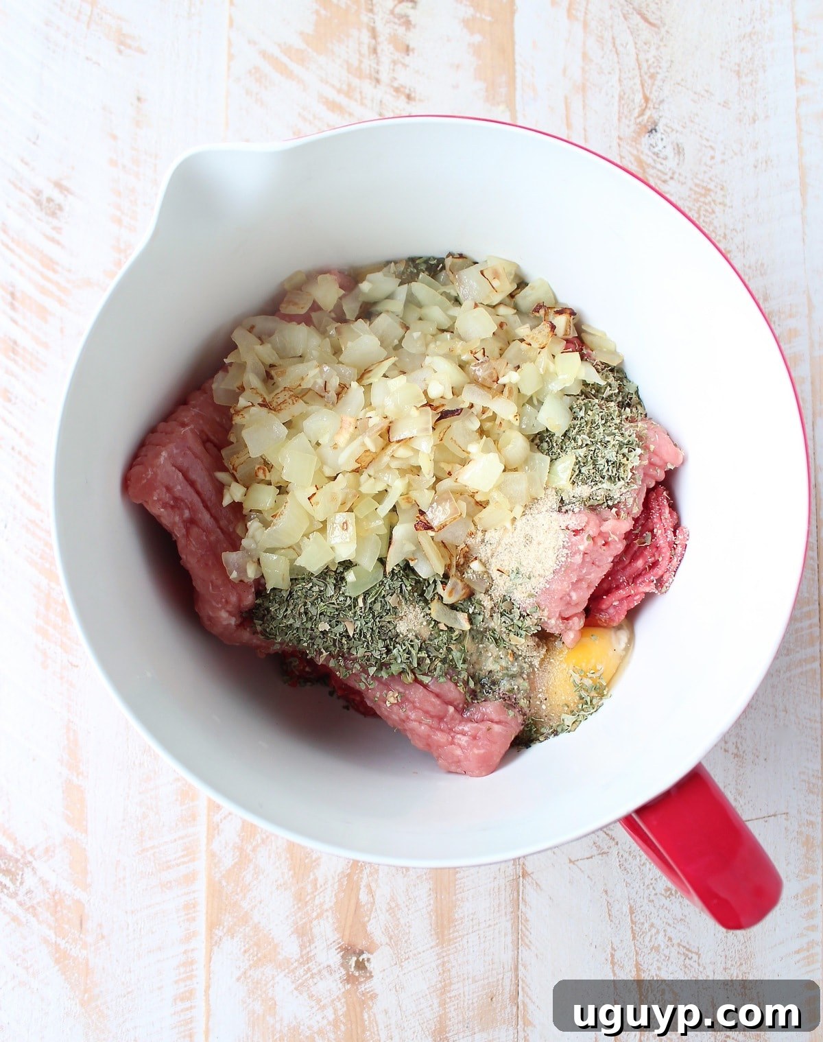 Mixing all the savory ingredients for the Italian Meatloaf, including ground beef, pork, herbs, and cheese.