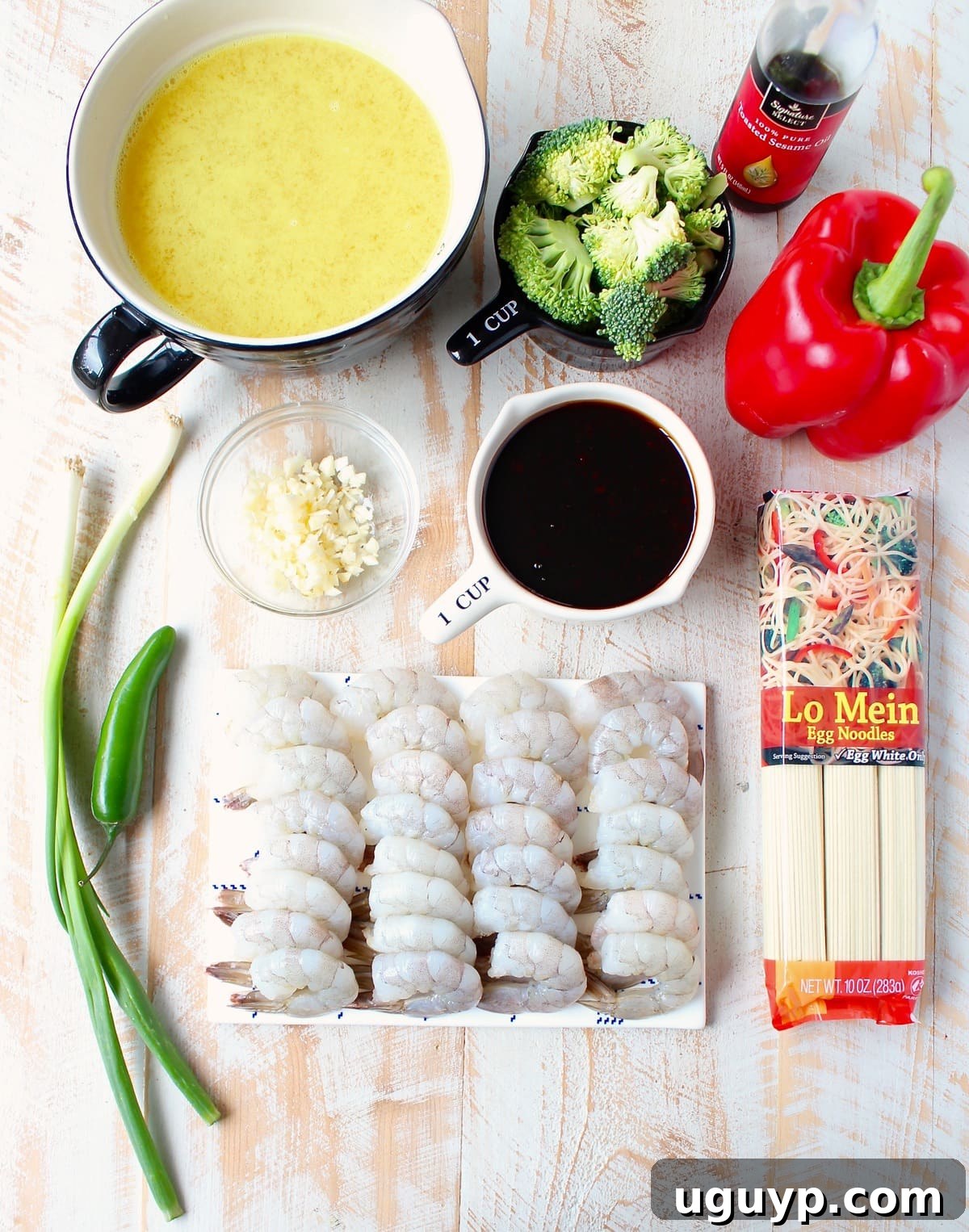 ingredients for teriyaki shrimp and lo mein on a white wood board