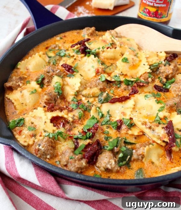 A bowl of creamy pesto ravioli with sausage and diced zucchini, ready to be enjoyed, highlighting the rich texture.