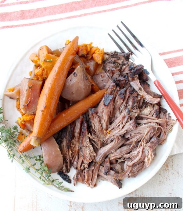 Garlic & herbs are rubbed on a beef chuck, then seared in bacon fat, placed in a crock pot & covered in red wine sauce for a tasty Slow Cooker Pot Roast!