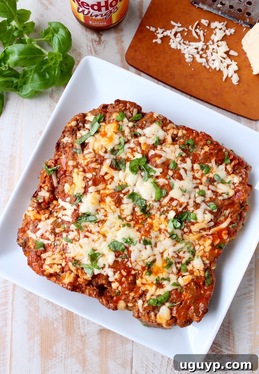 cooked cheesy meatloaf on square white plate