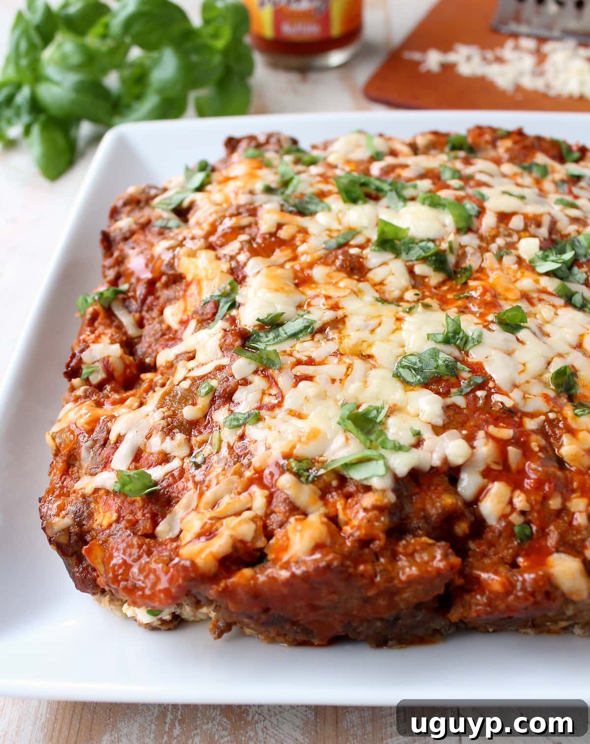 meatloaf on plate topped with melted shredded cheddar cheese