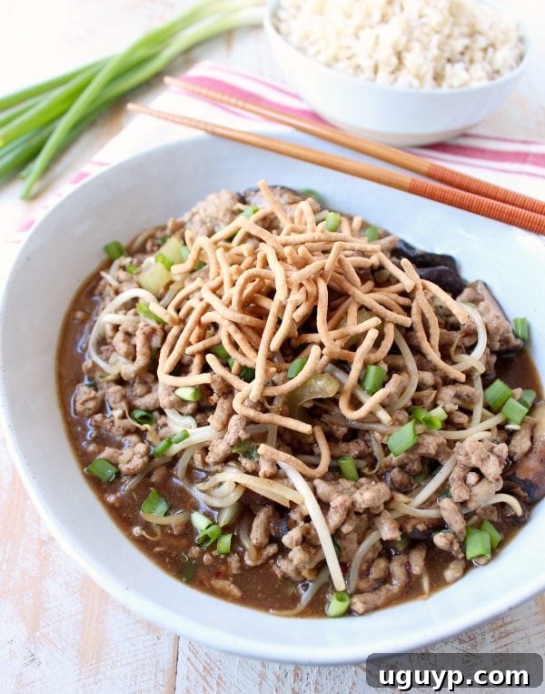 Close-up of Pork Chop Suey mixture with ground pork, sliced mushrooms, and green onions simmering in a skillet.