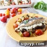 Sheet pan chicken is an easy, gluten free, one pan dish that takes under an hour to make. This recipe is stuffed with pesto and cheese, and served with zucchini and tomatoes!
