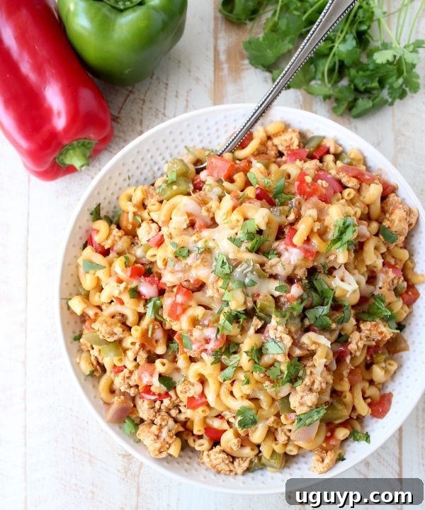 A large pot of creamy One Pot Chicken Fajita Pasta, topped with melted pepper jack cheese, ready to be served family-style.