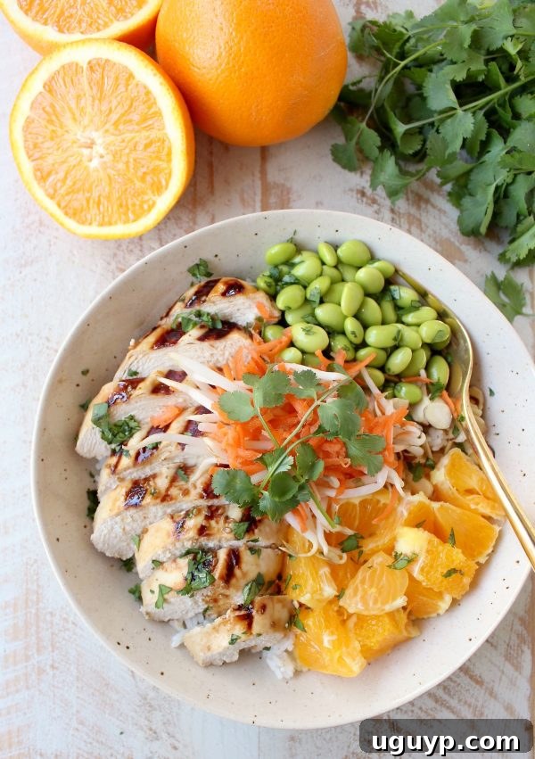 Sesame ginger marinated & grilled chicken tops these Healthy Asian Chicken Rice Bowls filled with oranges, almonds, veggies & tons of flavor!