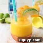 A vibrant Frozen Mango Margarita in a glass, ready to be enjoyed.
