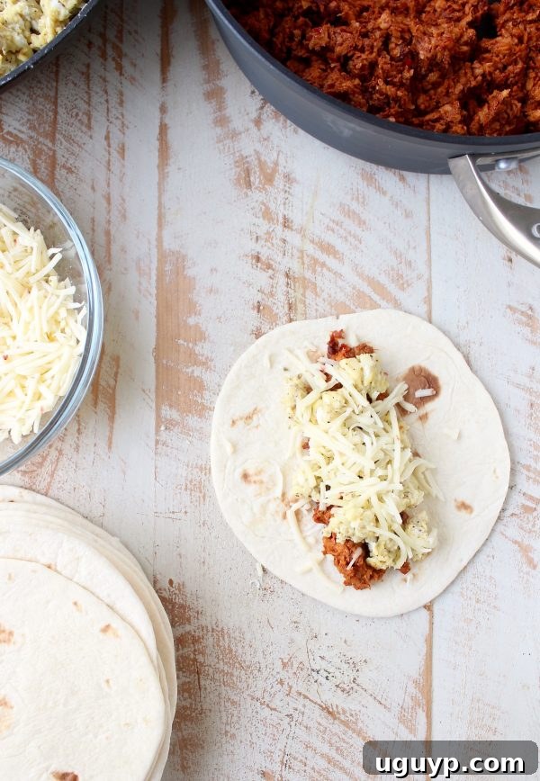 Filling being placed on a small flour tortilla: scrambled eggs, chorizo, and shredded pepper jack cheese.