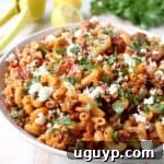 A vibrant close-up of One Pot Greek Pasta, showcasing its rich flavors with ground turkey, sun-dried tomatoes, capers, and crumbled feta cheese, ready in under 45 minutes.