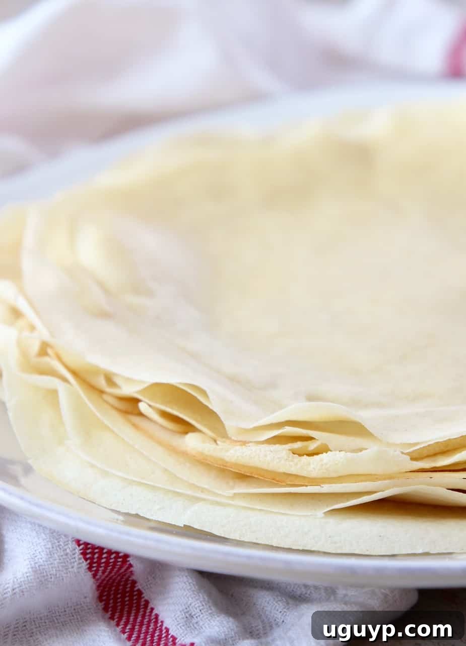 Delightful stack of golden-brown French crepes on a plate, ready to be filled and enjoyed.