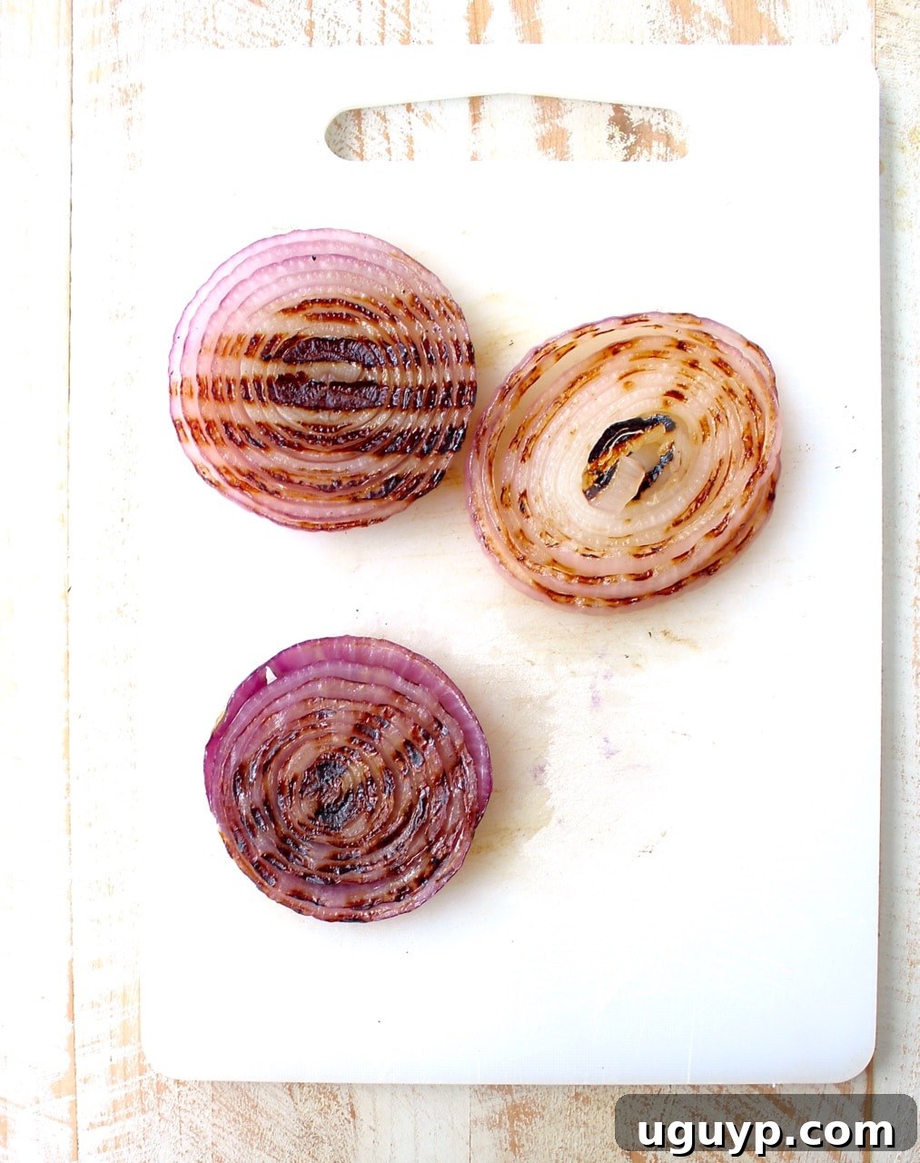 grilled slices of onions on cutting board