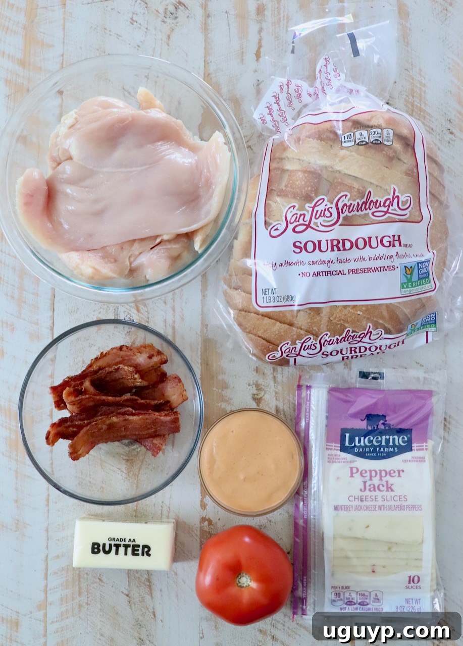 ingredients for spicy chicken panini on white wood board
