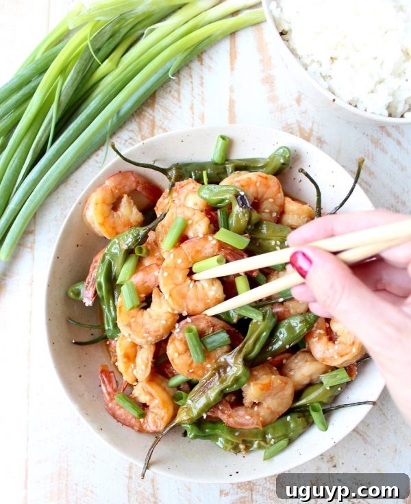 Delicious Shishito Shrimp Stir Fry drizzled with sauce in a hot wok