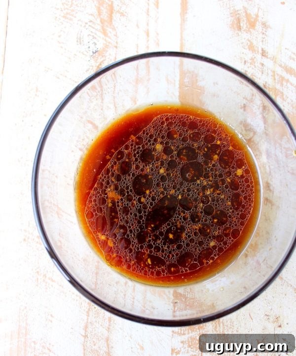 Mixing soy sauce, honey, sesame oil, lime juice, ginger, and garlic in a bowl