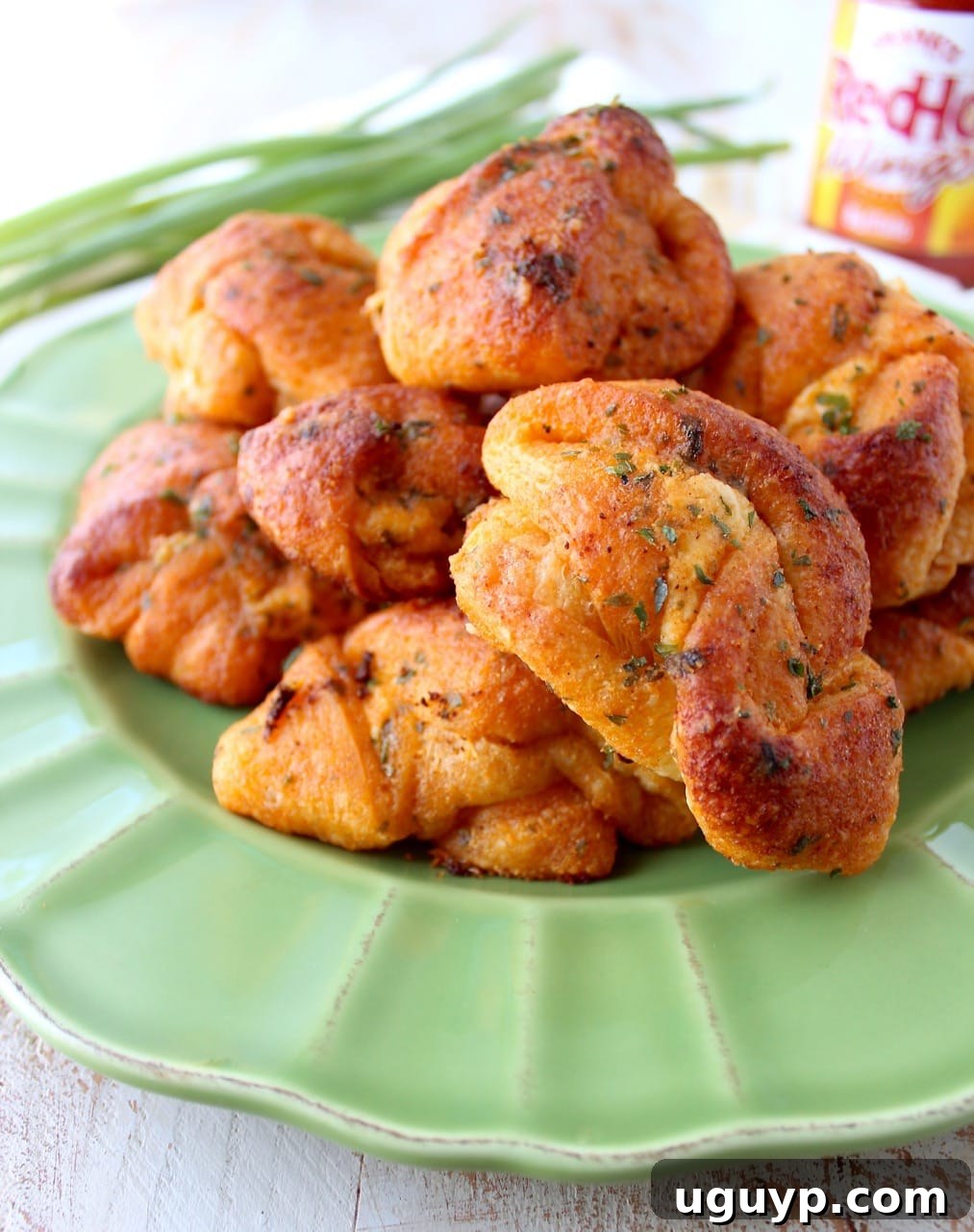 Mouth-watering Buffalo Cheesy Garlic Knots, perfect for an appetizer or party snack, filled with cheese and smothered in spicy buffalo sauce.