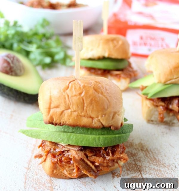 Hawaiian Chicken Sliders topped with fresh avocado slices on King's Hawaiian rolls.